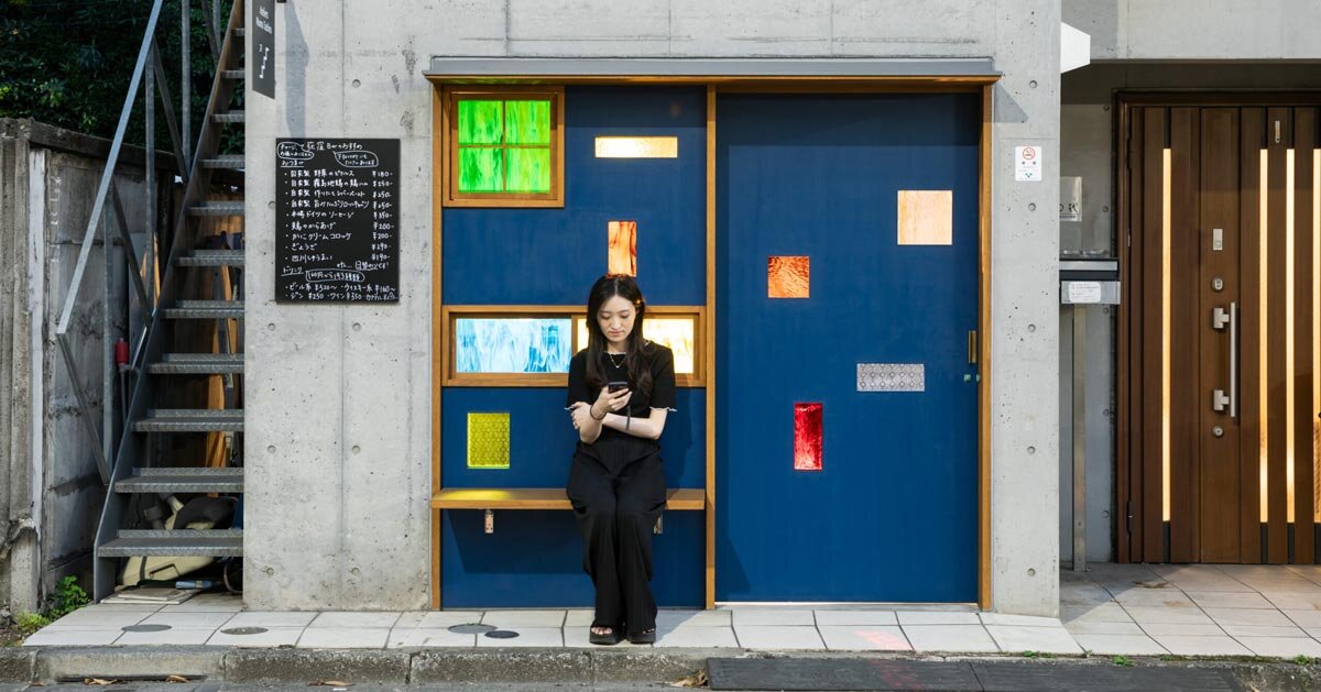 Molduras de vidro coloridas revelam o interior do Tokyo Bar através da porta azul