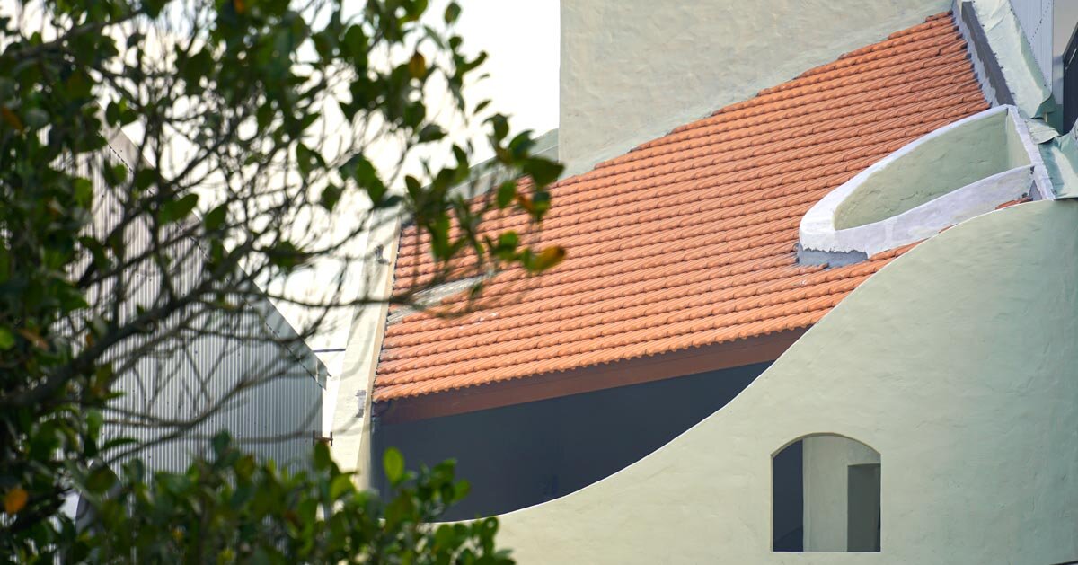 recortes curvos esculpem vazios fluidos em uma residência de duas águas no Vietnã