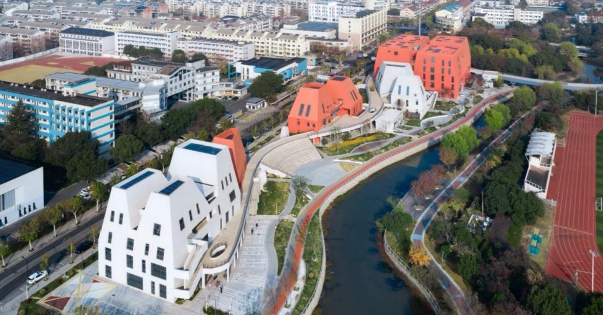 complexo esportivo geométrico vermelho e branco surge ao longo do rio daixi