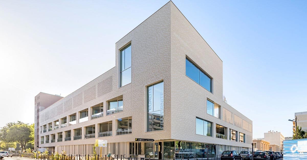 fachada de tijolos brancos envolve grupo escolar na França por Brenac & Gonzalez & Associés
