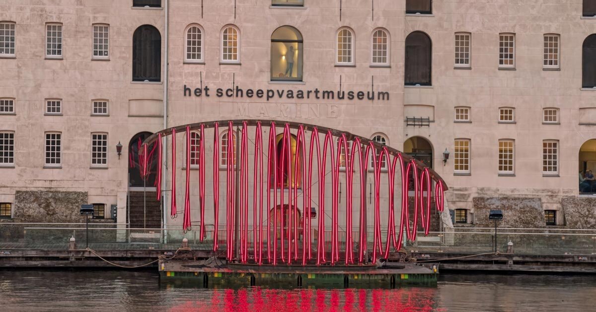 Instalação de luz esquelética de baleia brilha em vermelho para o Festival da Luz de Amsterdã