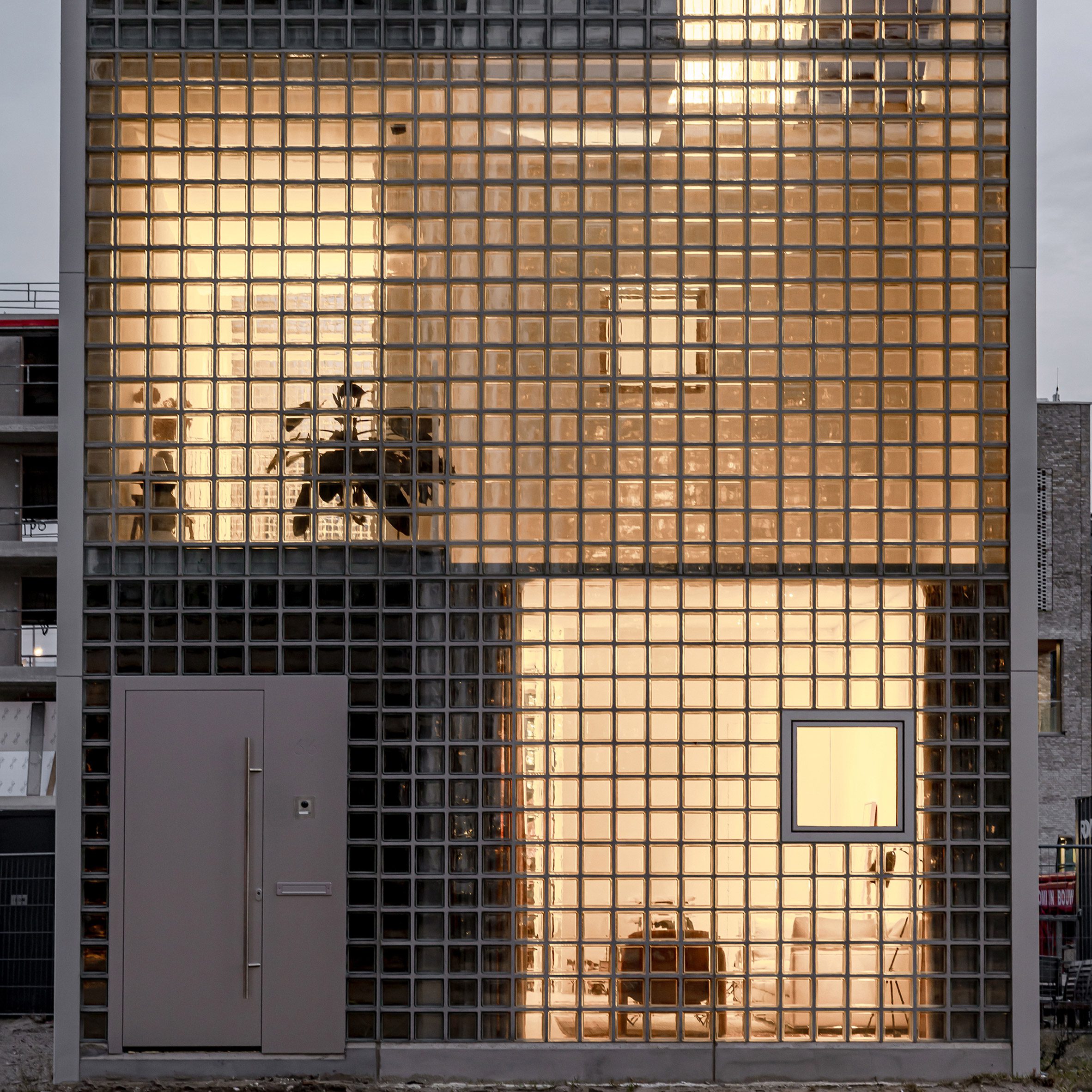 Studioninedots fica na frente de uma casa estreita em Amsterdã com blocos de vidro